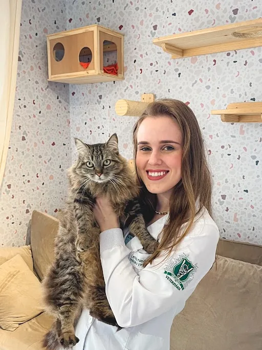 Letícia Neuberger segurando um gato durante atendimento domiciliar em Joinville